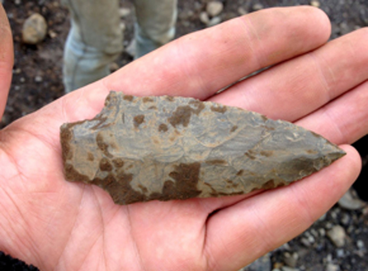 person holding a projectile point