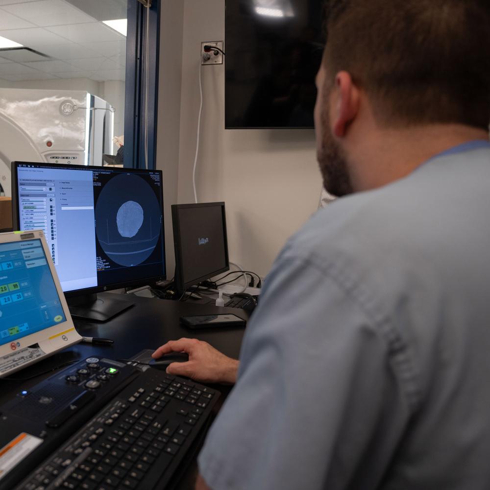 Medical Staff observe a computer screen displaying the scan of a dinosaur egg