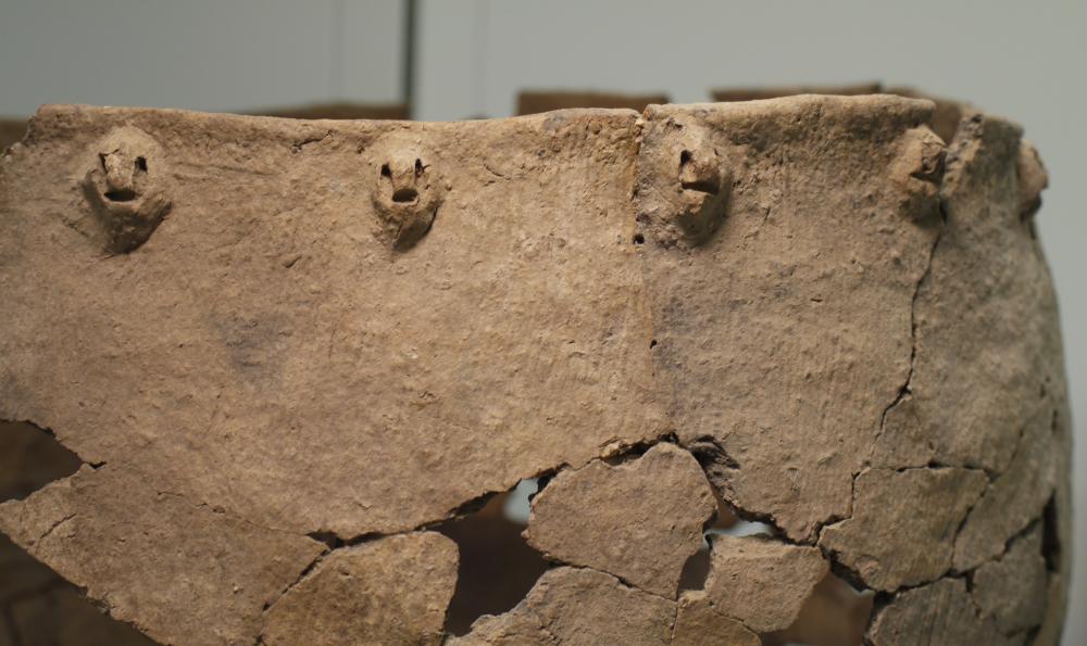 Detail of the Suffern Rockshelter pot rim, showing appliqued human faces (eyes and mouths formed by short oblong punctate impressions). This pot is pictured in "Recent Contributions to Hudson Valley Prehistory," by Robert Funk, former NYS archaeologist. Detail of Suffern Rockshelter pot
