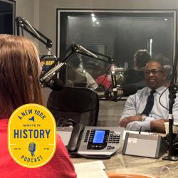 A woman sits across from a man in an audio booth conducting an interview