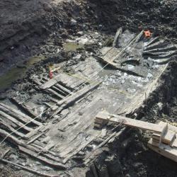 Excavation site showing boards and debris of a wooden ship 