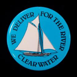 Round blue and white button with text and sailboat image.