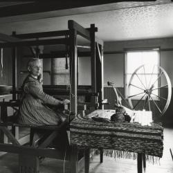 Sister Jennie Wells weaving at a loom 