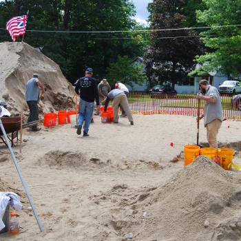 View of backdirt pile and shoveling crew in mid-August 2019