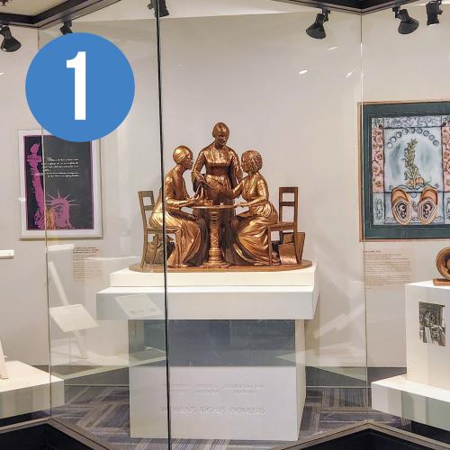 gallery view of Suffrage related items including posters and a small-scale statue