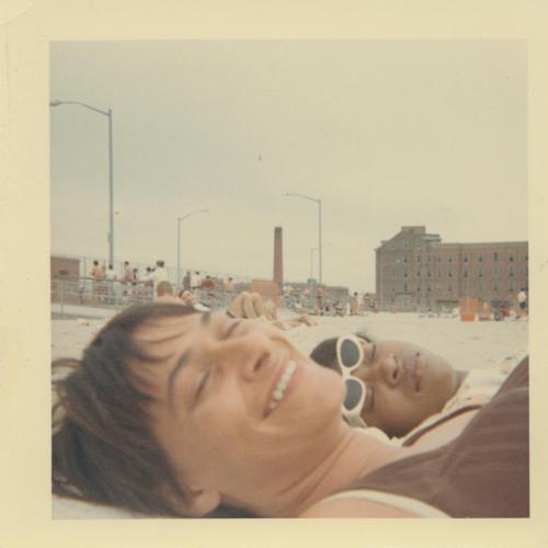 Two women laying on a beach