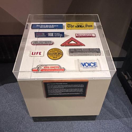 exhibit case containing a variety of newspaper weights