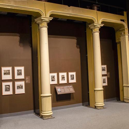 gallery view of photographs by Berenice Abbott hung on a wall behind a row of white pillars