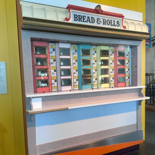 Photo of a rainbow-colored vending machine with the title "Bread & Rolls" at the top