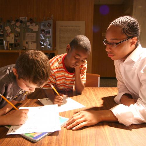 3 boys reading and doing homework