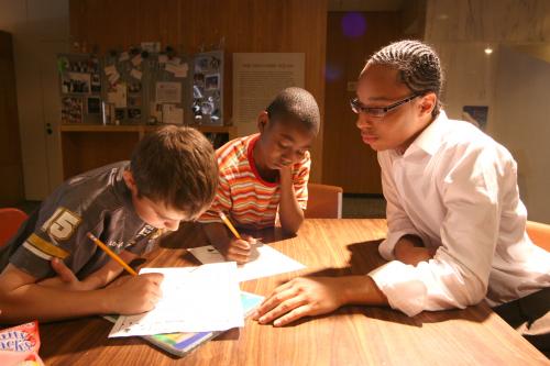3 boys reading and doing homework