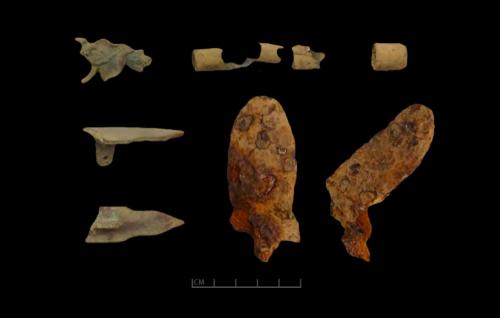 Gun Hardware from Fort Franklin including a floral escutcheon, brass ramrod guides, a brass buttplate finial, and an iron frizzen