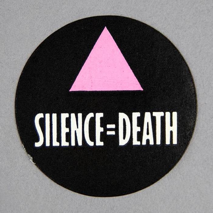 Circular button with pink triangle over "Silence = Death" on a black background
